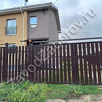 Забор из коричневого металлического штакетника